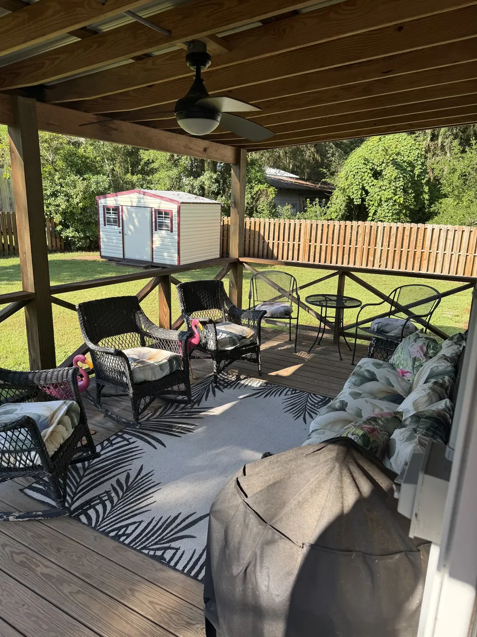 Covered back deck at Sapelo House with patio seating, ceiling fan, and relaxed outdoor living space.
