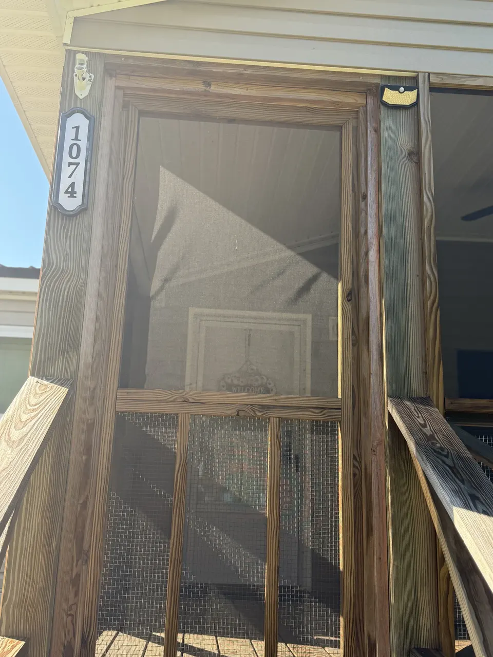 Screened front door entry at Sapelo House with wood trim and porch details.